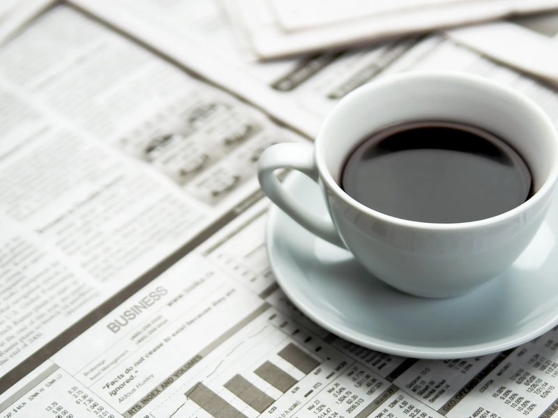 A cup of coffee on the newspaper from Carpet 4 Less in Antioch